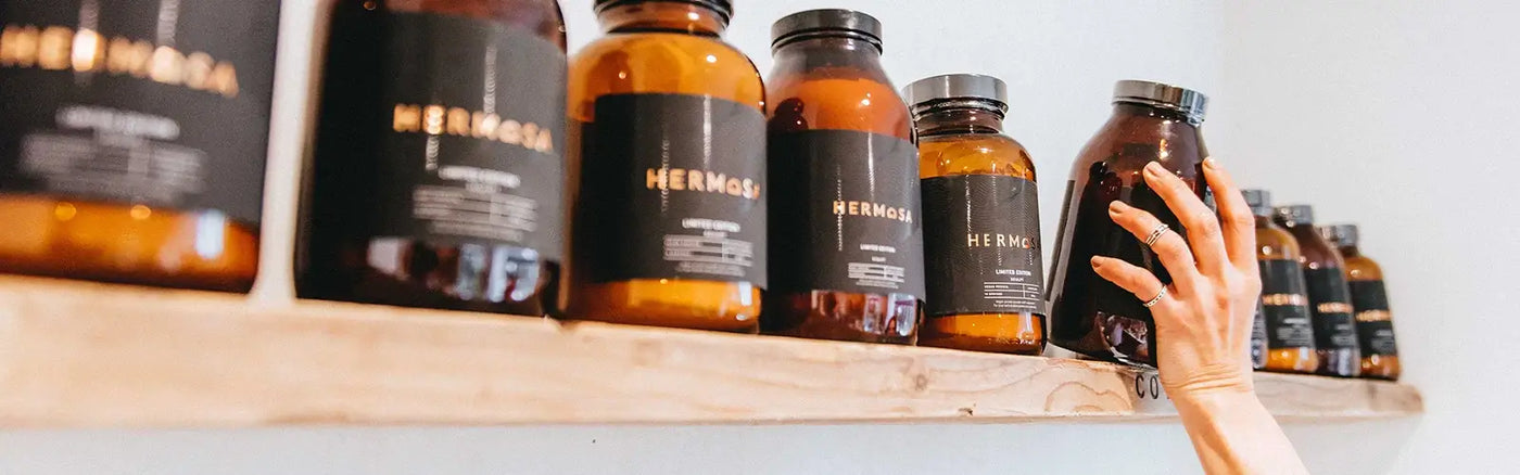 HERMOSA Protein Powders on a wooden shelf